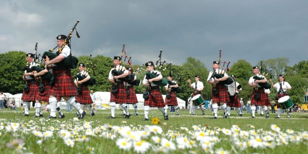 bagpipe band in a meadow conversation about wants and needs