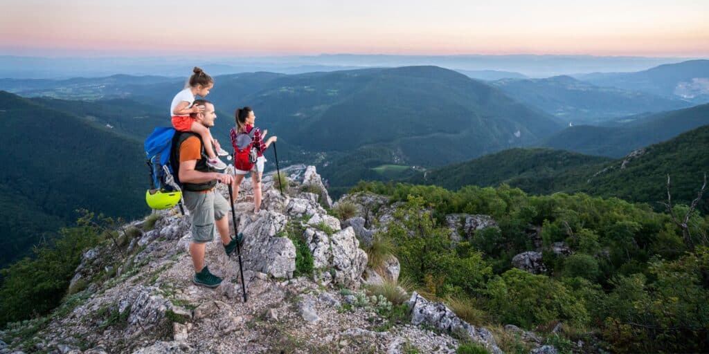 when to not give money to family image shows a small family that has hiked to the top of a rocky outcrop